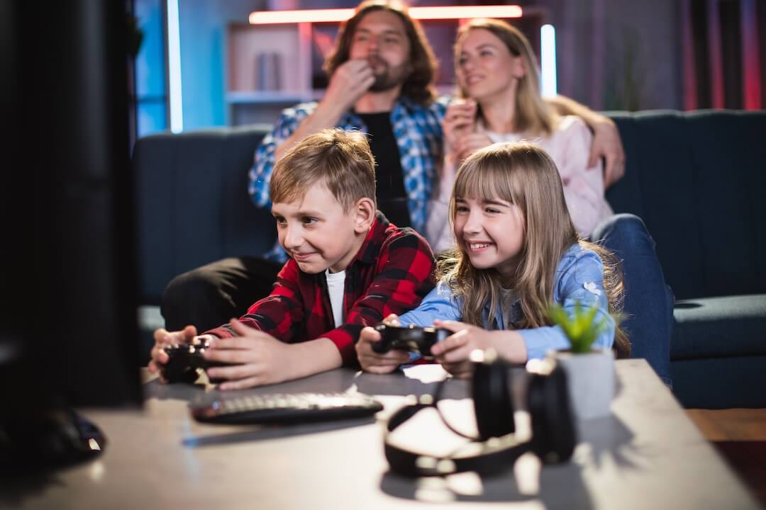 Parents watching son and daughter play on tv